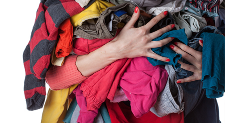 woman holding a bunch of clothes stock image